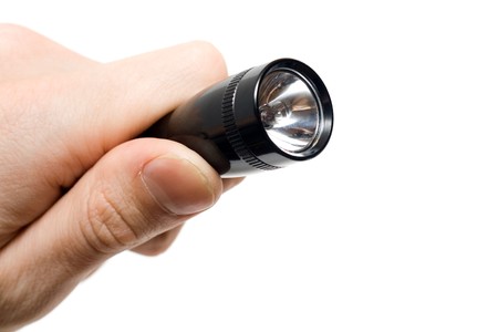 Black flashlight in a hand isolated on white.の写真素材