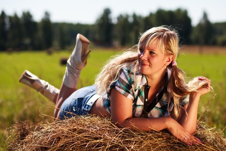 Country girl on straw bale.の写真素材