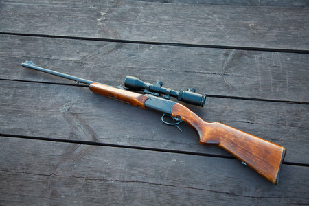 Sniper rifle with optical sight on wooden table.の写真素材