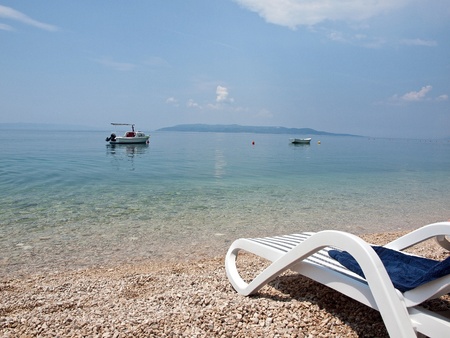 Deck chair with towel on beach with view to the island Hvar and blue seaの写真素材