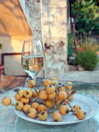 Glass of wine with mediterranean friuts on tableの写真素材