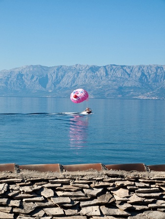 Boat with smilley parachute on seaの写真素材