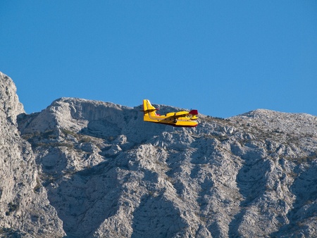 Fire fighter airplane flying near big mountain