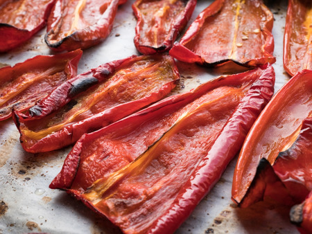 Roasted red peppers close up on baking trayの写真素材