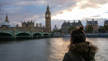 Woman looking at Westminster palace and Big Ben at sunsetのeditorial素材