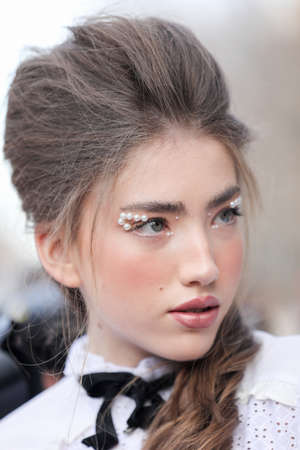 February 19, 2020: model in the foreground wears a white blouse and a makeup with pearls during the Armani fashion show at the women`s fashion weekのeditorial素材