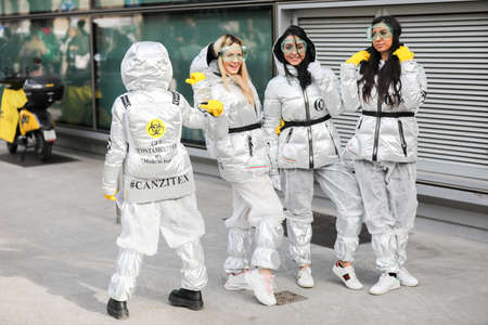 February 19, 2020: models wear a silver down jacket, silver pants, yellow gloves and protective glasses during the Armani fashion show at the women`sのeditorial素材
