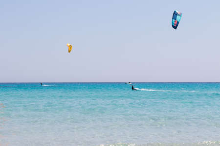 July 23, 2021: boys practicing kitesurfing in the crystal sea near the beach of La Cinta, Sardiniaのeditorial素材