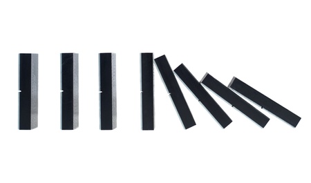 Falling dominoes isolated on a white backgroundの写真素材