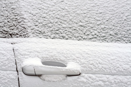 parked car covered with snow during snowing in winter timeの写真素材