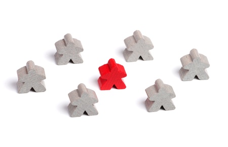 Red wooden figure surrounded by gray ones on white backgroundの写真素材