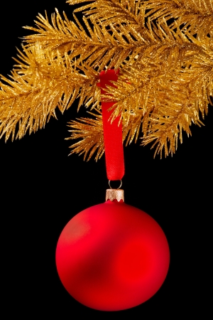 Red Christmas ball on a ribbon against black backgroundの写真素材