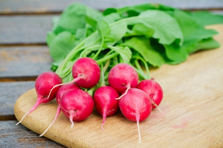 Fresh radishes on a wooden cutting boardの写真素材