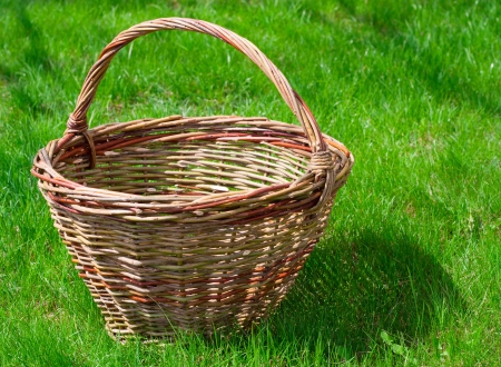Old wicker basket on a green garden grassの写真素材