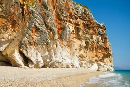 Beautiful sunny beach surrounded by high cliff wallの写真素材