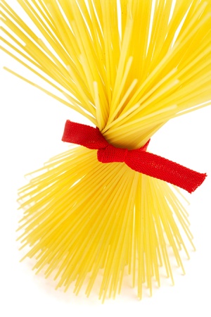 Bunch of spaghetti tied up with red ribbon isolated on whiteの写真素材