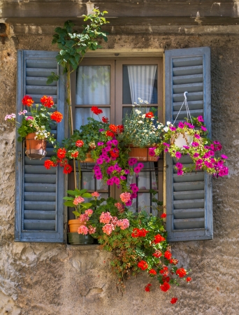 Vintage window with open wooden shutters and fresh flowersの写真素材