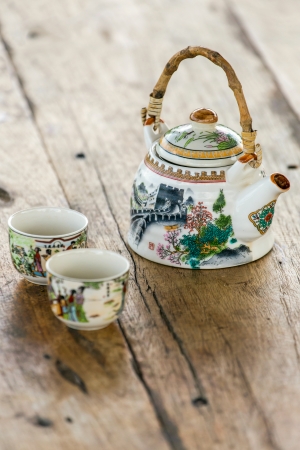 Chinese porcelain teapot and two cups on a wooden tableの写真素材