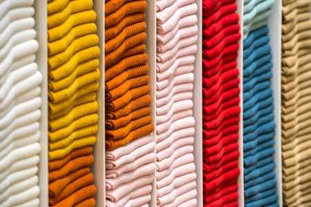 Neat stacks of folded clothing on the shop shelvesの写真素材