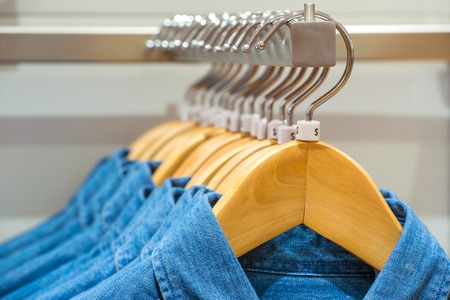 Jeans shirts on the hangers in the clothing storeの写真素材
