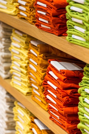 Neat stacks of folded clothing on the shop shelvesの写真素材