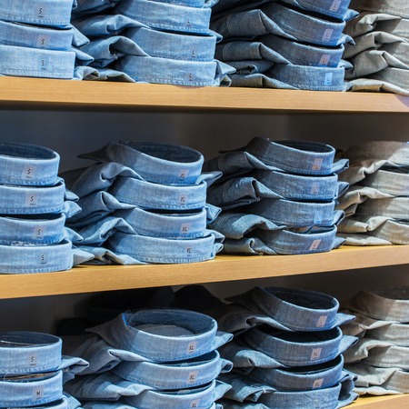 Neat stacks of folded clothing on the shop shelvesの写真素材