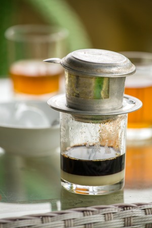 Glass of strong vietnamese filter dripping coffeeの写真素材