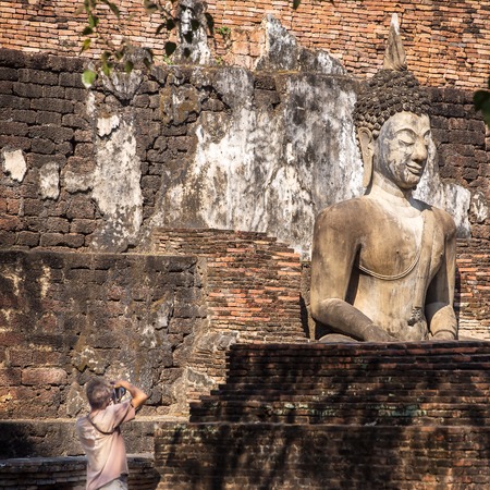 SUKHOTAI,THAILAND - FEBRUARY 4, 2013: Tourists making picture in Sukhotai Historical Park. The Sukhothai Historical Park covers the ruins of Sukhothai, capital of Sukhothai kingdom in the 13th and 14th centuriesのeditorial素材