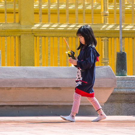 CHIANG MAI, THAILAND - JANUARY 25, 2014 :Unknown thai girl, pray before a Buddhist temple. The vast majority of people in Thailand are Buddhists.のeditorial素材