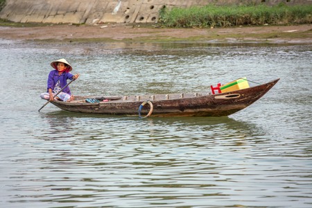 HOI AN, VIETNAM - MARCH 31: Woman driving the fishing boat in Hoi An, Vietnam on March 31, 2014.のeditorial素材