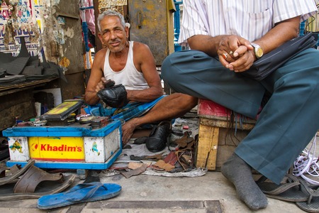 KOLKATA, INDIA - MARCH 14: Unidentified shoe shiner does his job at street of Kolkata on March 14, 2013. Lots of people make their living by doing this job in India.のeditorial素材