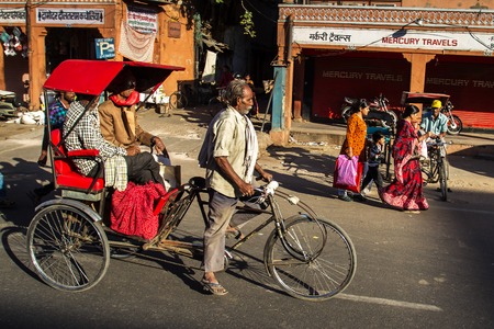 JAIPUR, INDIA - NOVEMBER 25: Rickshaw rider transports passenger early morning on November 25,2012...