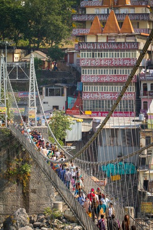 RISHIKESH, INDIA - 2012 NOVEMBER 13: People crossing Lakshman Jhula bridge over Ganges on November 13, 2012 in Rishikesh, India.のeditorial素材