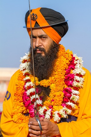 JAIPUR, INDIA - NOVEMBER 28, 2012: Sikh devotee with orange turban and flowers during street parade on November 28, 2012 in Jaipur, India.のeditorial素材