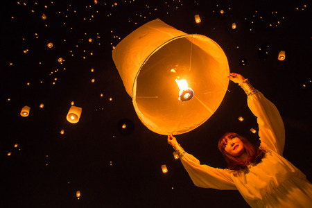 CHIANG MAI, THAILAND - NOVEMBER 8, 2014: Unidentified woman release Khom Loi, the sky lanterns during Yi Peng or Loi Krathong festival on November 8, 2014 in Mae Jo University, Chiang Mai, Thailand.のeditorial素材