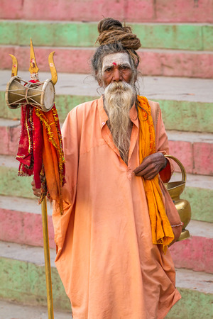 VARANASI, INDIA - MARCH, 21: An unidentified sadhu - Hindu holy man seeks alms in front of a ghat along the river Ganges on March 21, 2013 at Varanasi, Uttar Pradesh, India.のeditorial素材