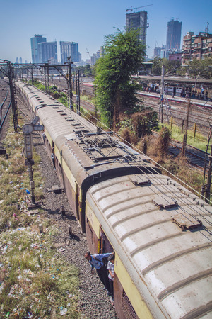 Mumbai, India - December 12, 2012: Unidentified local hangs himself outside the train on December 12, 2012 in Mumbai, India. Mumbai Suburban Railway carries more than 7 million commuters on a daily basis.のeditorial素材