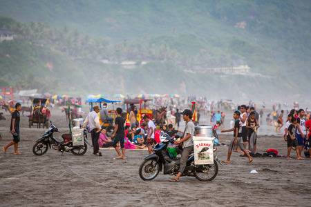 YOGYAKARTA, INDONESIA-APRIL 18, 2015: Food vendors and tourists on the black sand Parangtritis beach in Java, Indonesiaのeditorial素材