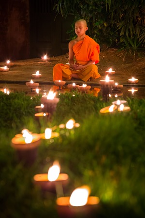 Chiang Mai, Thailand - November 6, 2014: Buddhist monk meditating during Loy Kratong Festival, on November 6, 2014 in Phan Tao Temple, Chiangmai, Thailand.のeditorial素材