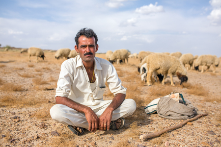Jaisalmer, India - March 13, 2016: Portrait of unidentified rajasthani shepherd with his sheeps outside of Jaislamer, Rajasthan, Indiaのeditorial素材