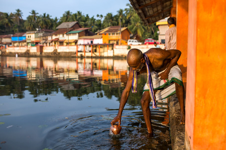Gokarna, India - January 16, 2016: Unidentified temple brahmin taking water for puja from sacred lake in Gokarna. The city is a holy pilgrimage site for Hinduistsのeditorial素材