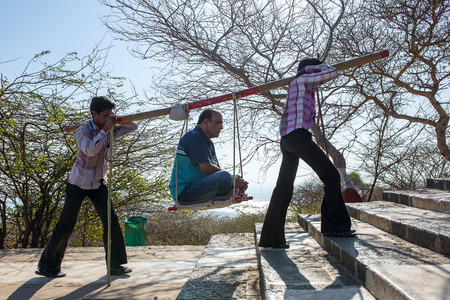 Palitana, India - March 6, 2016: Unidentified workers, carry pilgrims to the Jain temples on top of Mount Satrunjaya near Palitana, Gujarat, India.のeditorial素材