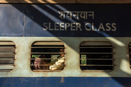 Gokarna, India - January 14, 2016: Unidentified passenger of the Indian Railway looking in the window of the train at Gokarna road station, India.のeditorial素材