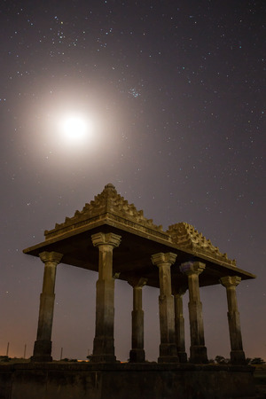 The royal cenotaphs of historic rulers, also known as Jaisalmer Chhatris, at Bada Bagh in Jaisalmer, Rajasthan, India. Night shot of ruins with a moonの写真素材