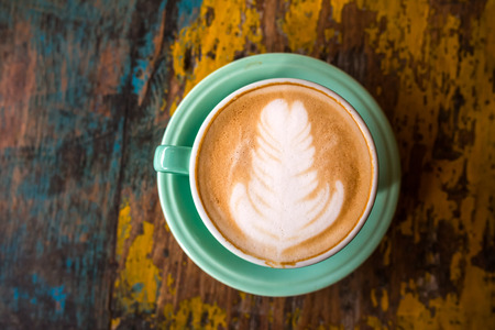 Coffee cup top view on old wooden table background.の写真素材