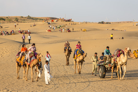 Jaisalmer, India - March 13, 2016: Indian tourists  riding camels in Thar desert, Rajasthan, Indiaのeditorial素材