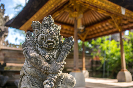Traditional guard demon statue carved in dark stone on Bali island, Indonesiaの写真素材