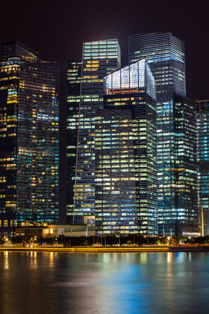 Office buildings at night in Singapore. Background with illuminated modern skyscrapersの写真素材