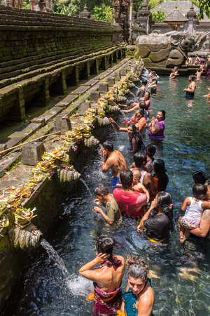 Bali, Indonesia - August 7, 2016: Balinese Hindu families come to the sacred springs of Tirta Empul in Bali, Indonesia to pray.のeditorial素材