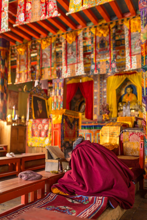 Ngawal, Nepal - May 6, 2016: Unidentified young buddhist monk praying in the monastery temple near Ngawal village, Nepalのeditorial素材